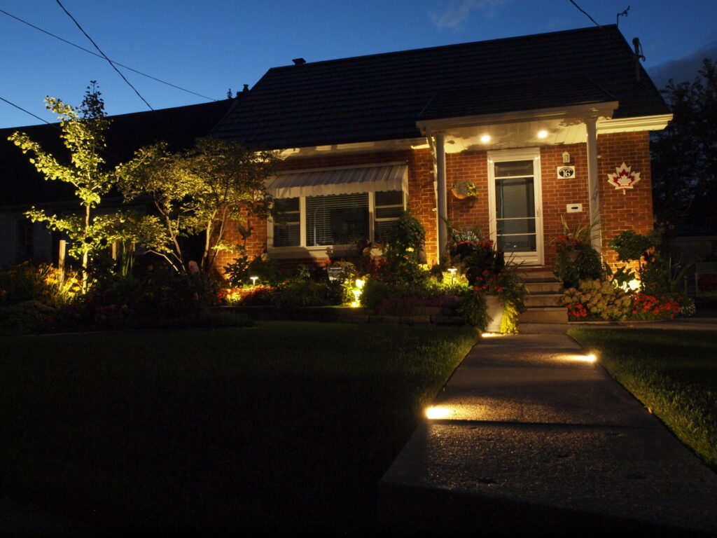 A red brick house is lit up at night.