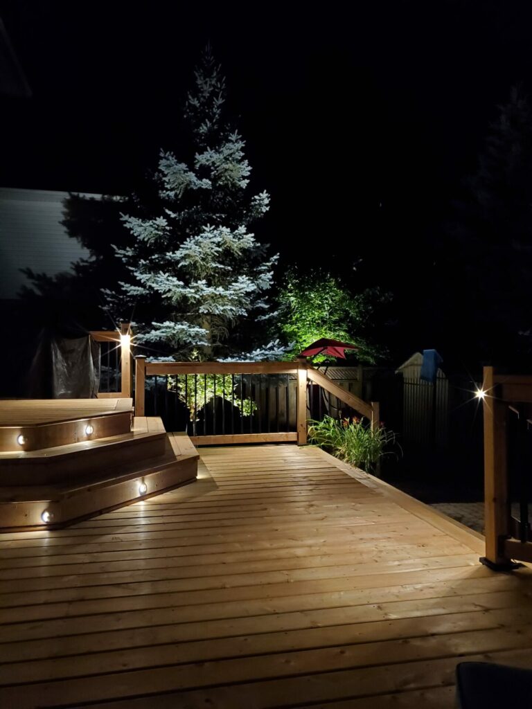 A wooden deck with lights at night.