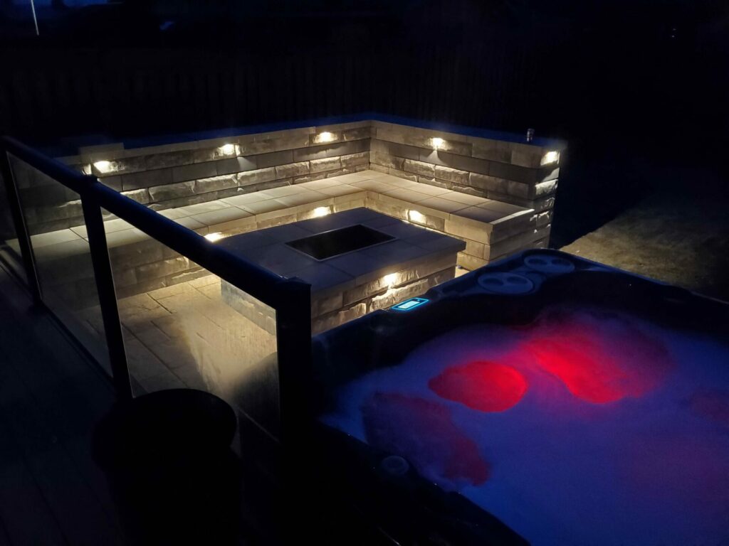 A hot tub is lit up at night.