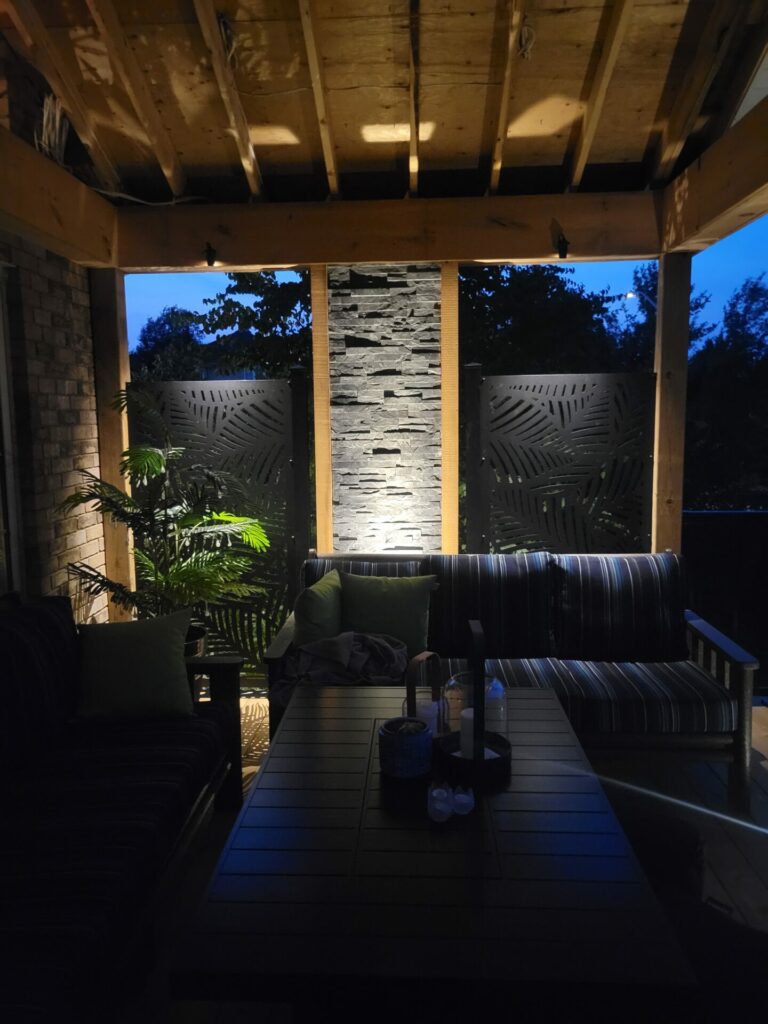 A patio with a table and chairs at night.