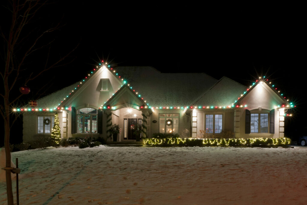 A house with Christmas lights in the snow.