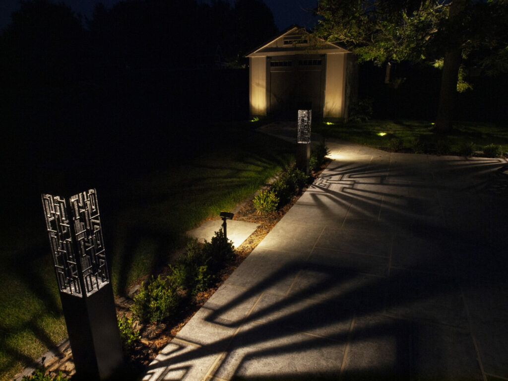 A pathway lit up at night with outdoor lighting.
