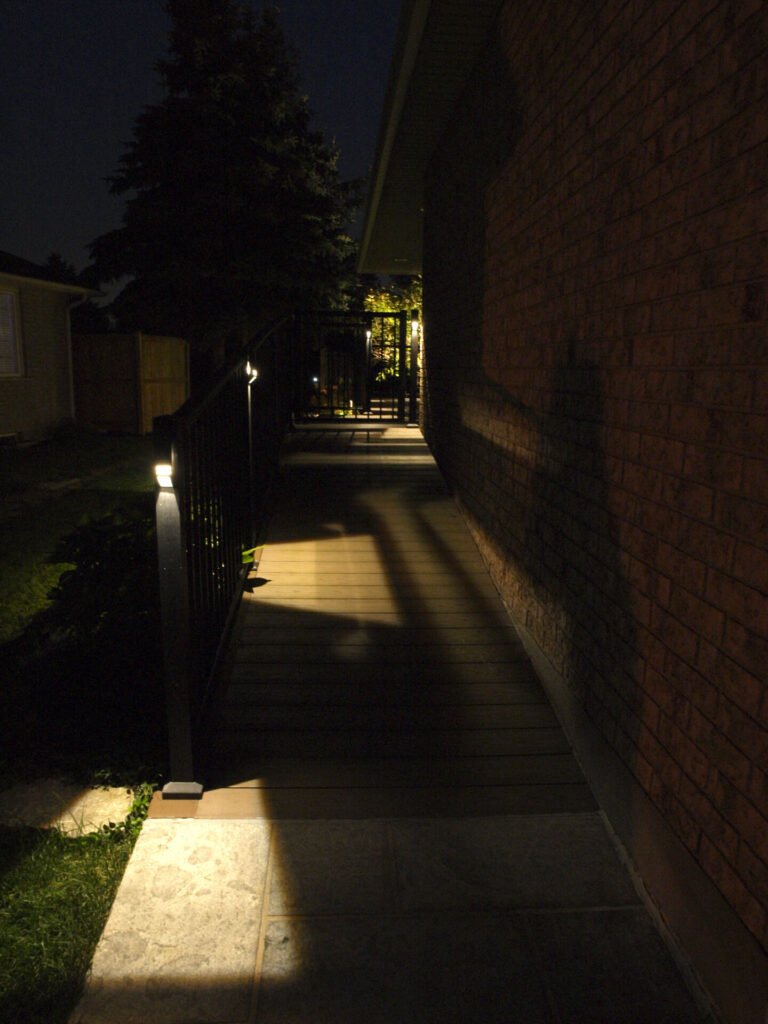 A walkway is lit up at night.