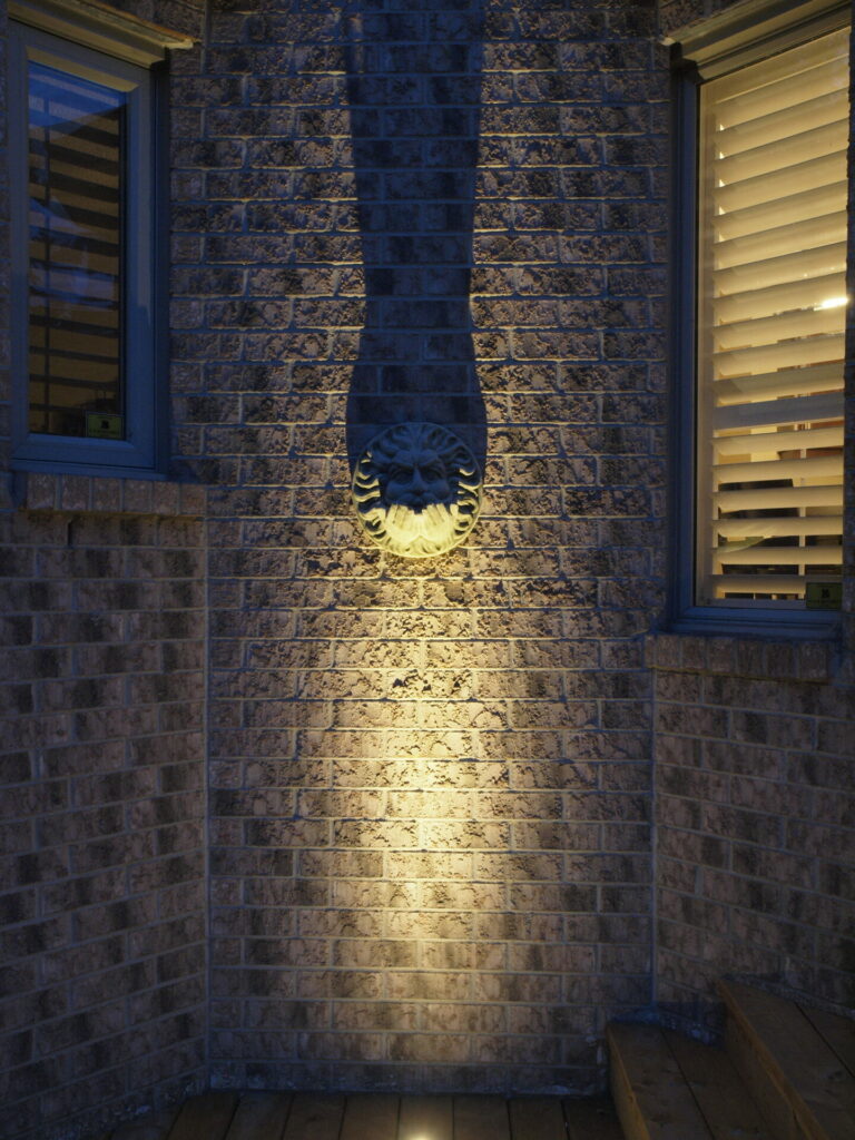 A brick wall is lit up at night.