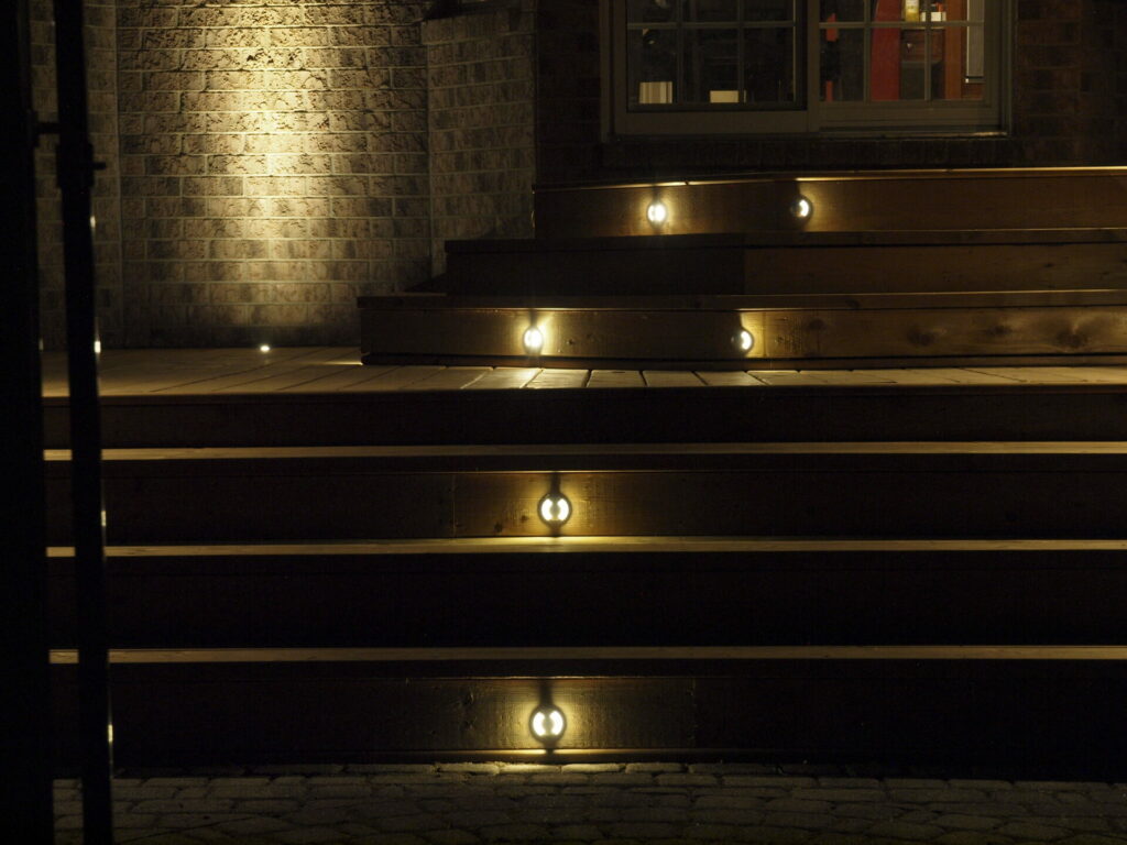 The wooden stairs are lit up at night.