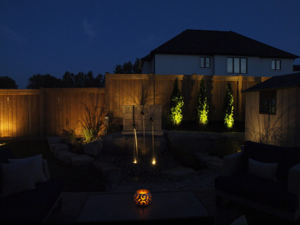 A backyard lit up at night with a candle on a table