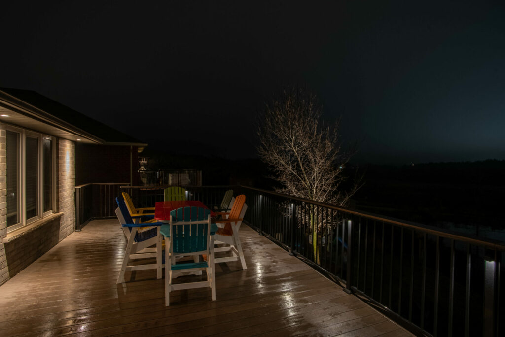 A deck with outdoor furniture and lights at night.