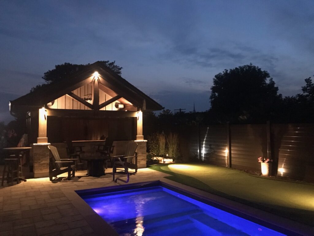A pool and a pool house at night.