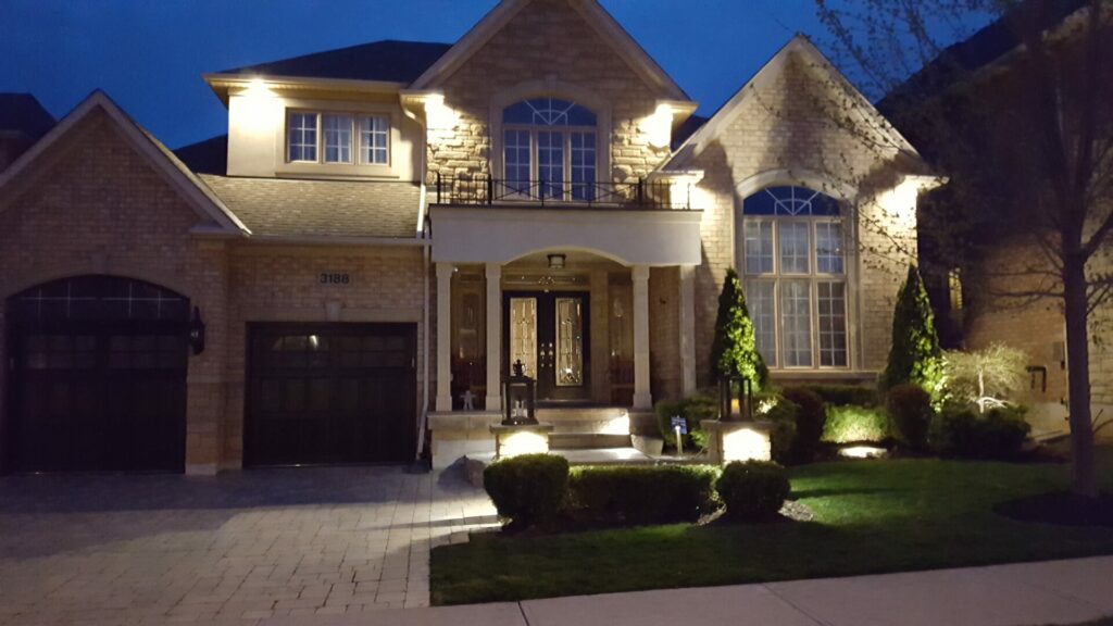 A home with a driveway lit up at night.
