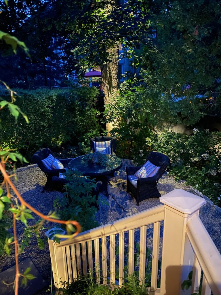 A backyard with a table and chairs at night.