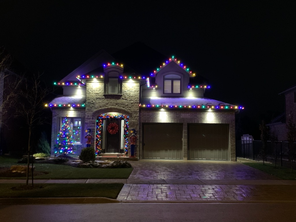 A house is lit up with Christmas lights at night.
