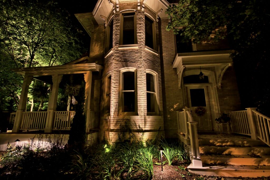A large, brick house is lit up at night.