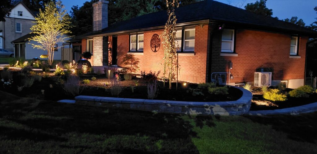 A home is lit up at night with landscape lighting.