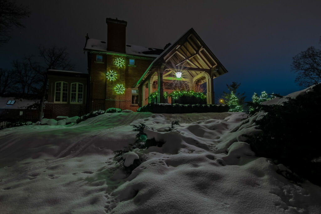 A house is lit up at night in the snow.